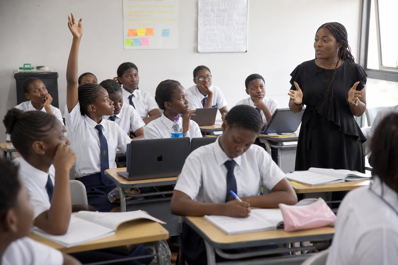 African tutor teaching a live online coding class to Nigerian secondary school students
